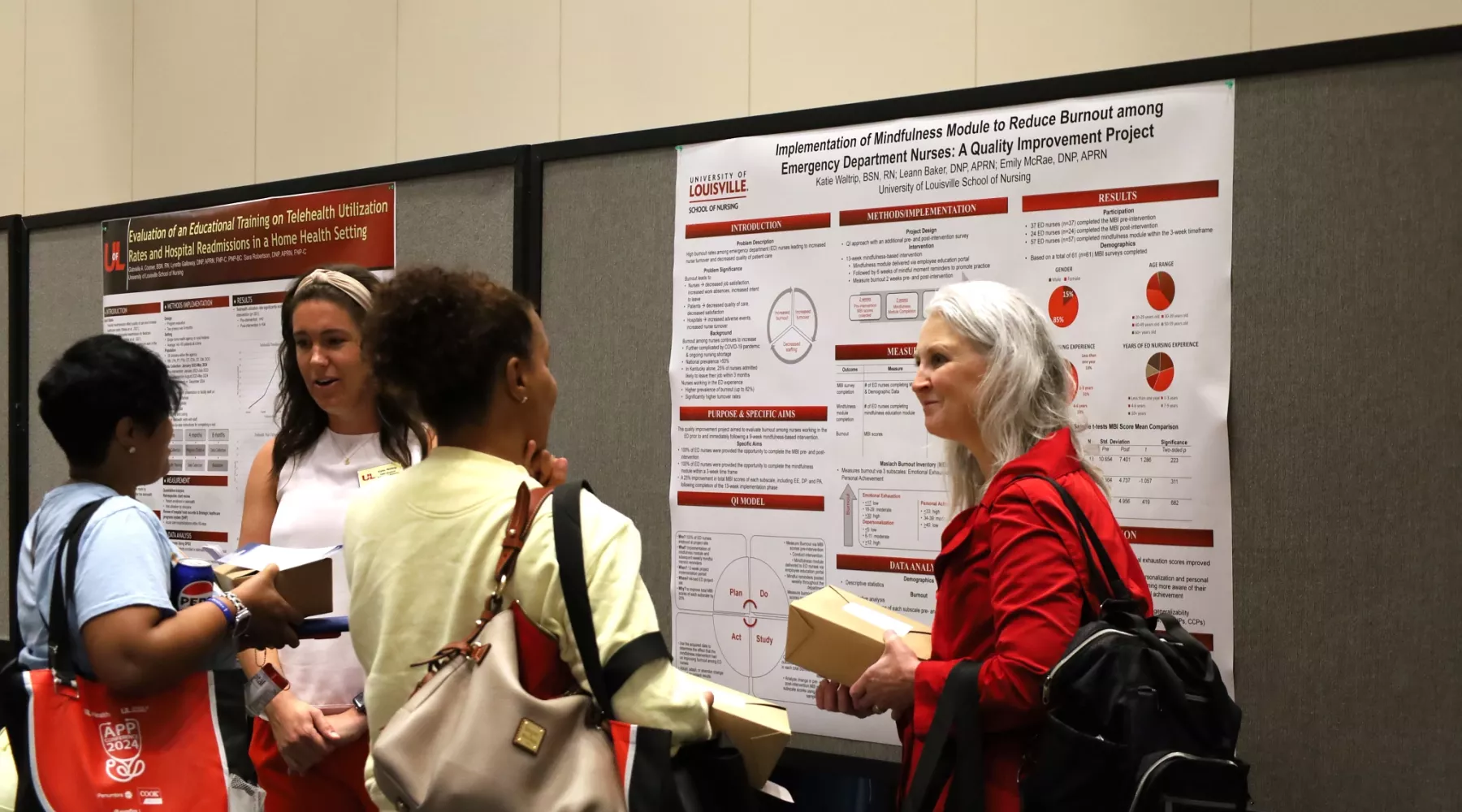 DNP student and DNP faculty member Dr. Leann Baker engaged in poster presentation conversation with two guests.