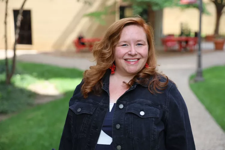 University of Louisville School of Nursing Academic advisor, Lauren McCurdy, standing outside the School of Nursing building on a sunny day, smiling at the camera.